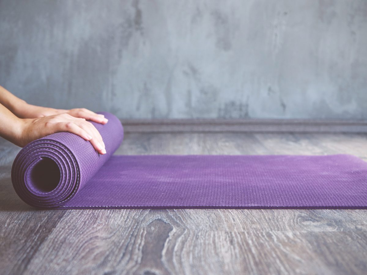 A person is unrolling a yoga mat