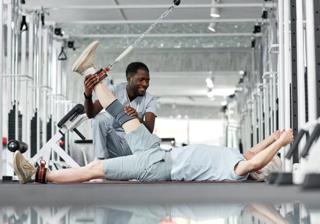 At the SportsMed clinic, a therapist guides a man through exercises