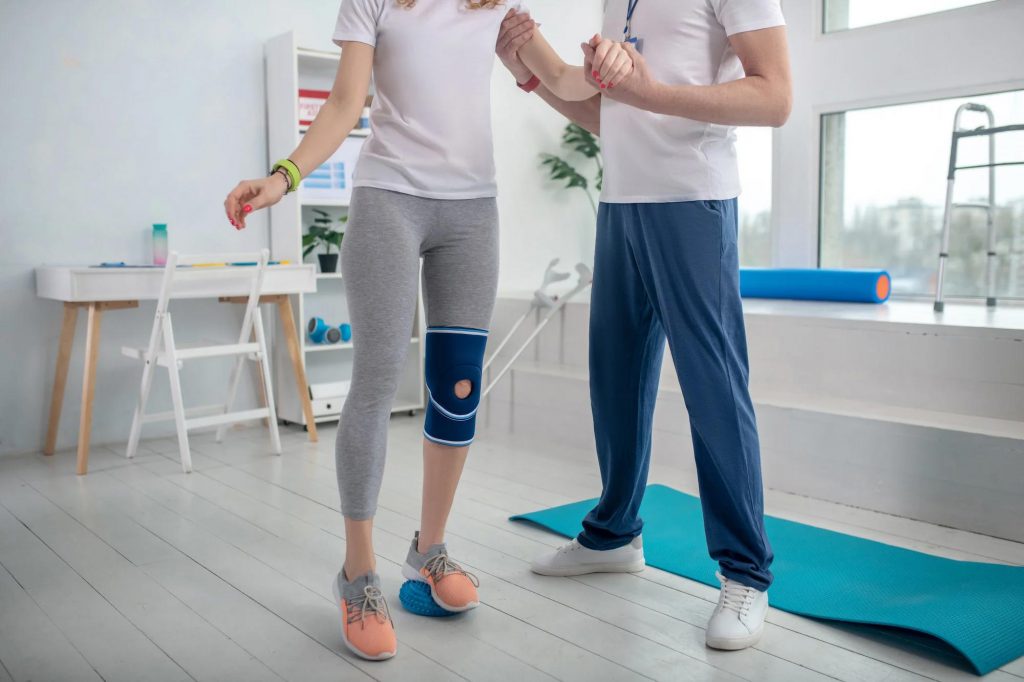 At SportsMed clinic, a male physiotherapist assists a female patient with balance exercises, ensuring her rehabilitation journey is smooth and effective.