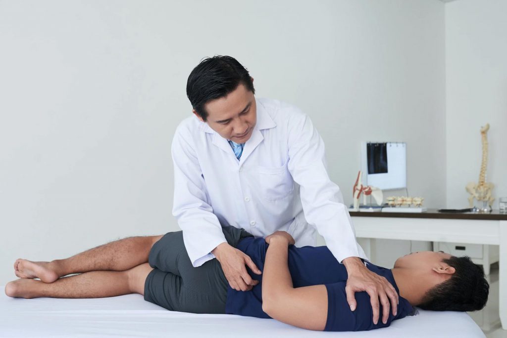 A young man undergoing chiropractic treatment in SportsMed to alleviate discomfort in their joints and muscles