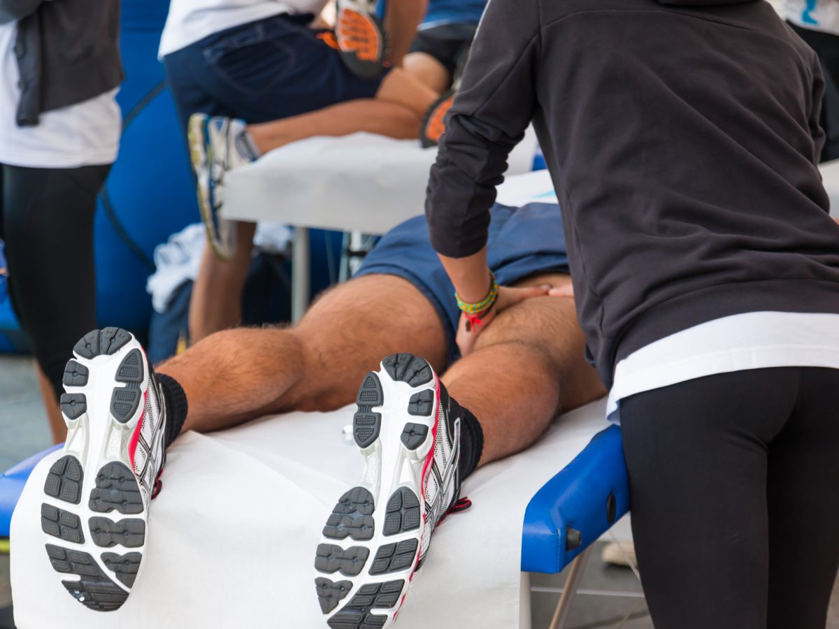 A SportsMed practitioner assisting a patient in recuperating from a hamstring strain