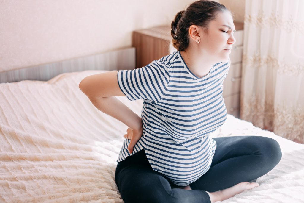 Pregnant woman having back aches, pain
