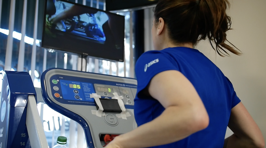 A woman is jogging on a treadmill