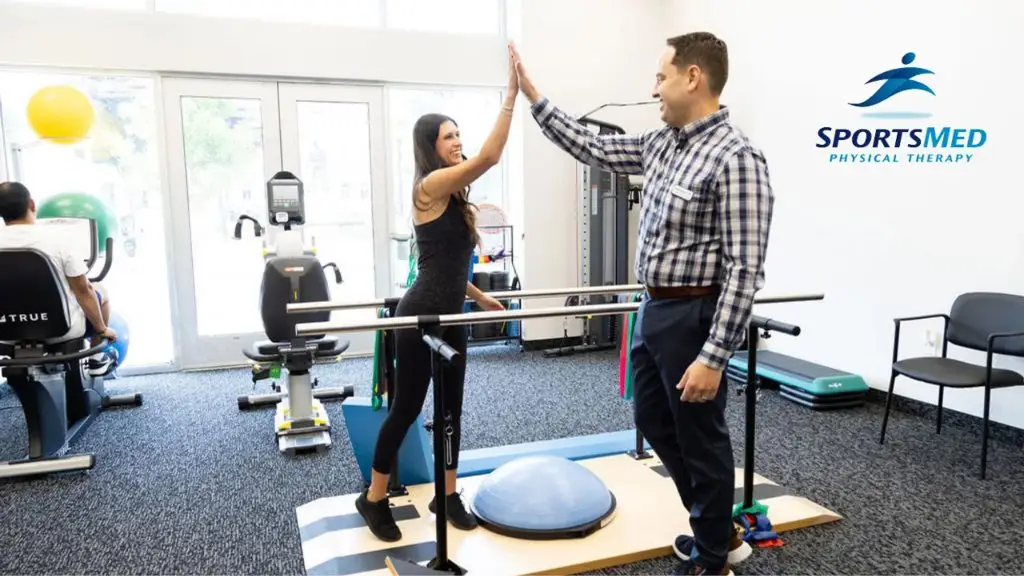 Sportsmed therapists and patient give a high five doing exercises.