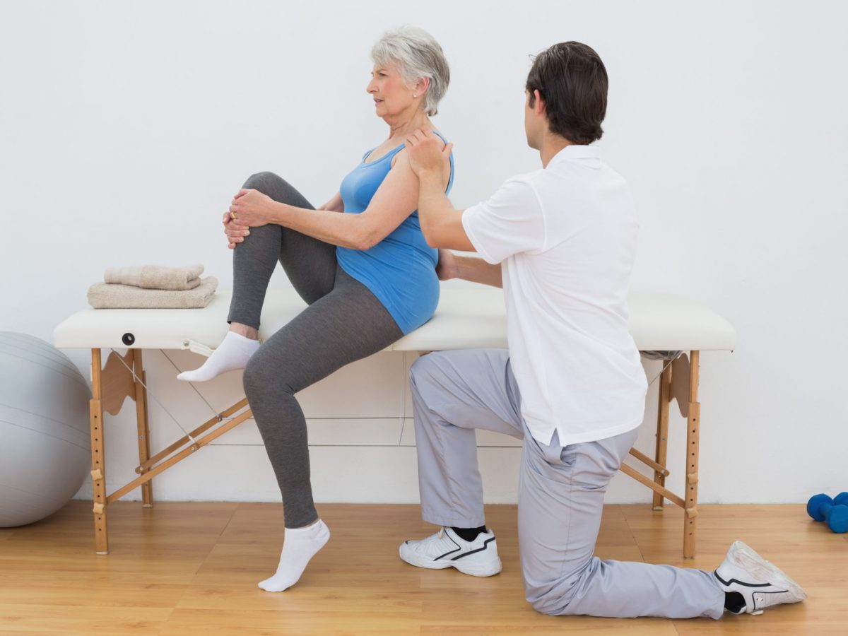 A SportsMed physical therapist is guiding a woman through her physical activities
