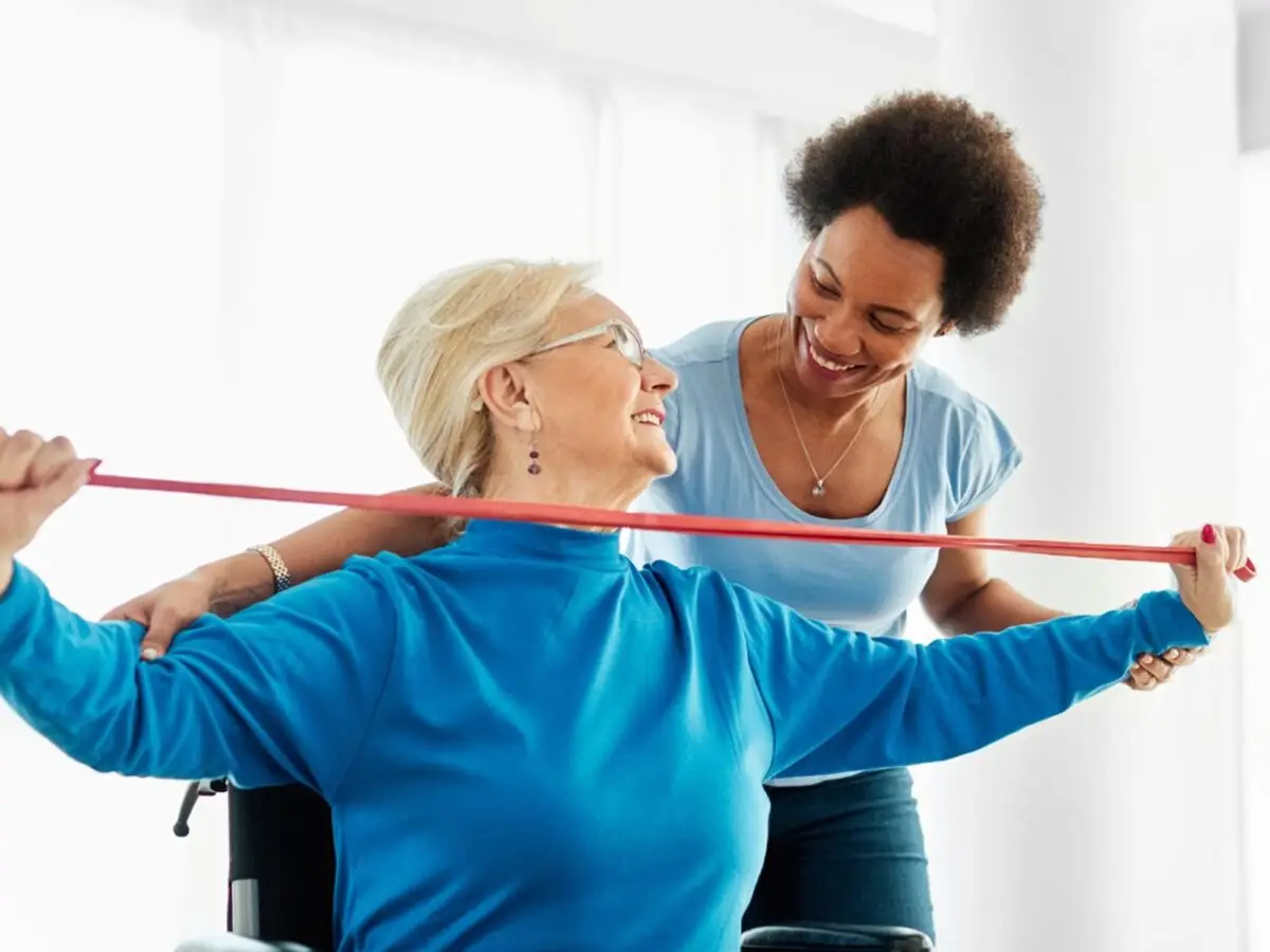Image of female physical therapist working with an older female patient who is in a wheelchair