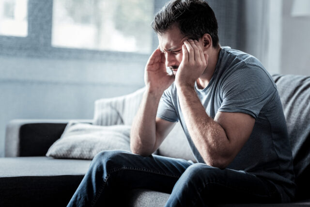 fatigued young man suffering from migraine