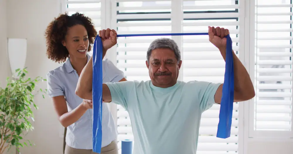 Physical therapist assisting a patient with exercises for pain management.