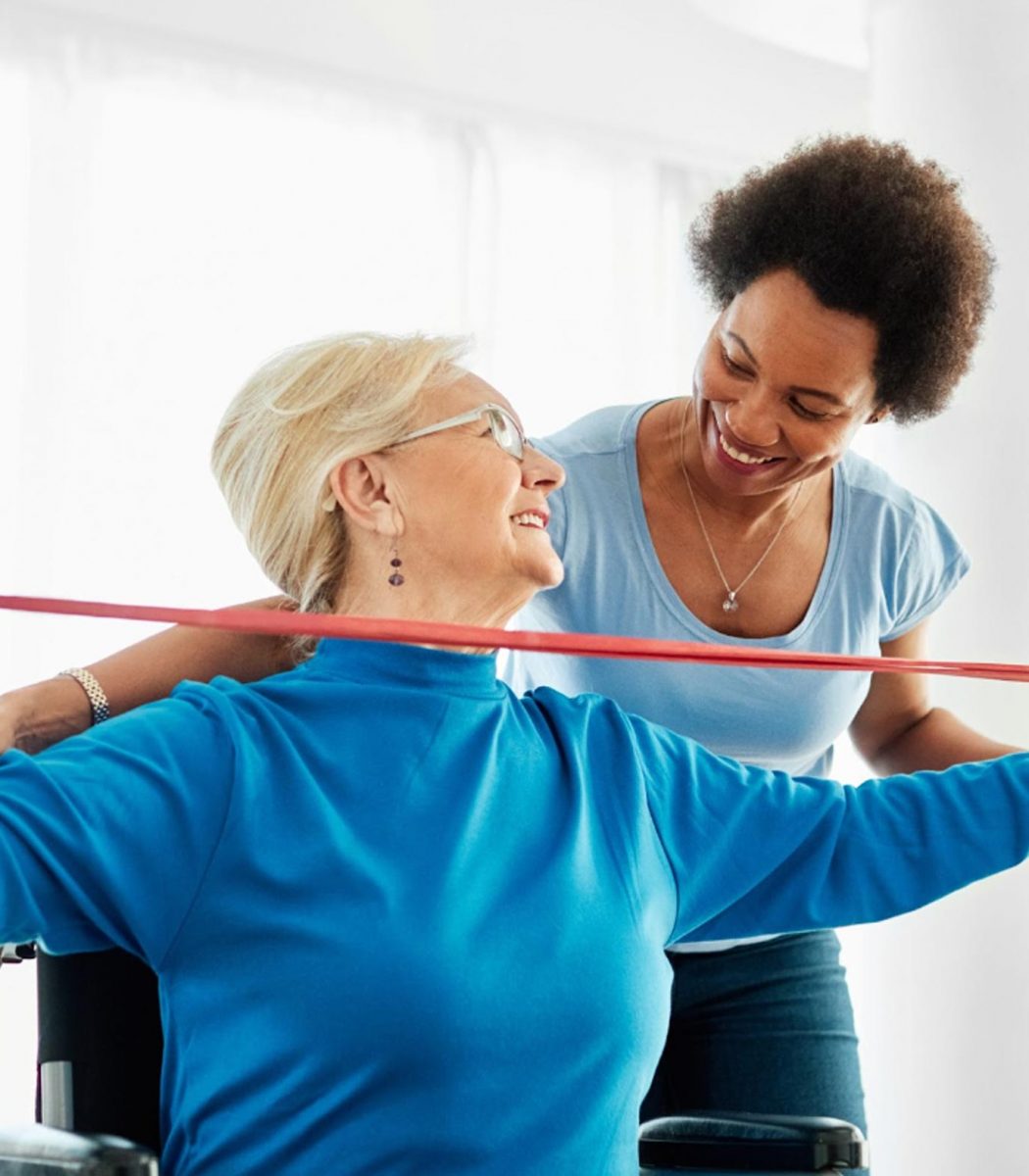 Image of female physical therapist working with an older female patient who is in a wheelchair