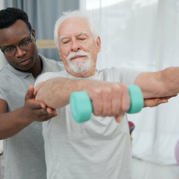 A therapist instructing an elderly man on exercise techniques.