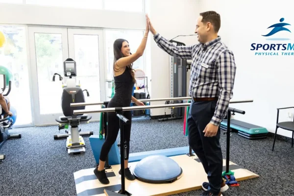 Sportsmed therapists and patient give a high five doing exercises.